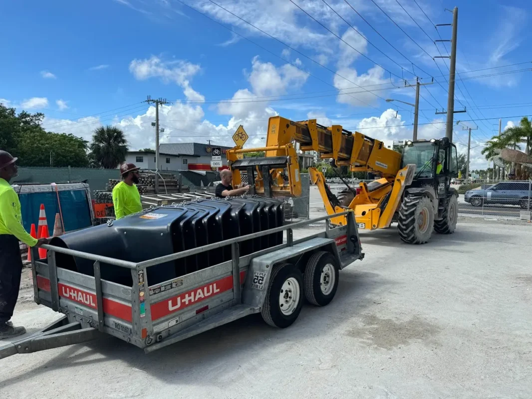 worker installing construction trash chute system using electric winch for safe debris management
