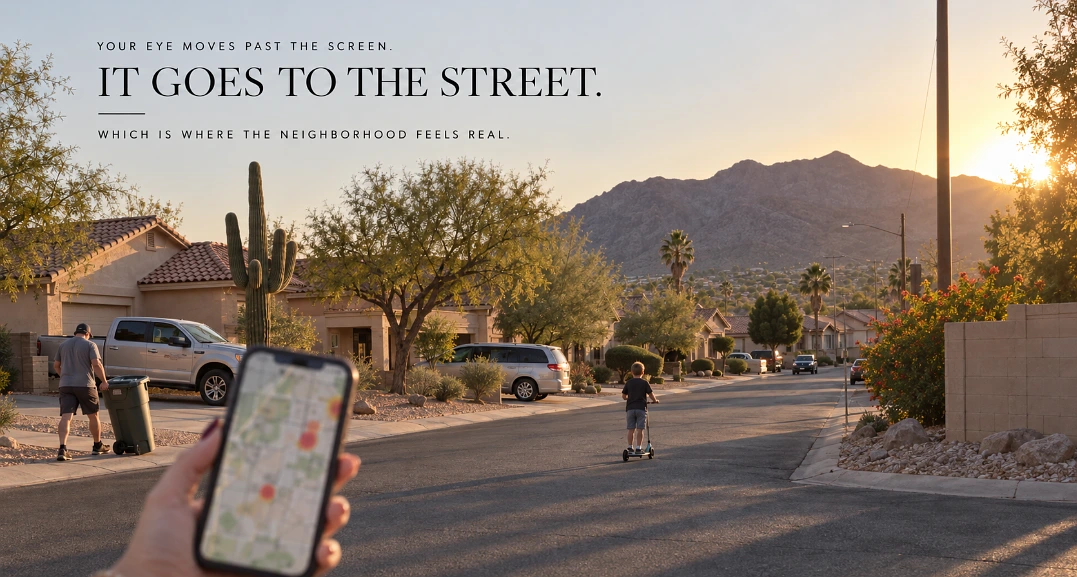 Hand holding a phone with a city map in front of a quiet Ahwatukee street of stucco houses at sunset